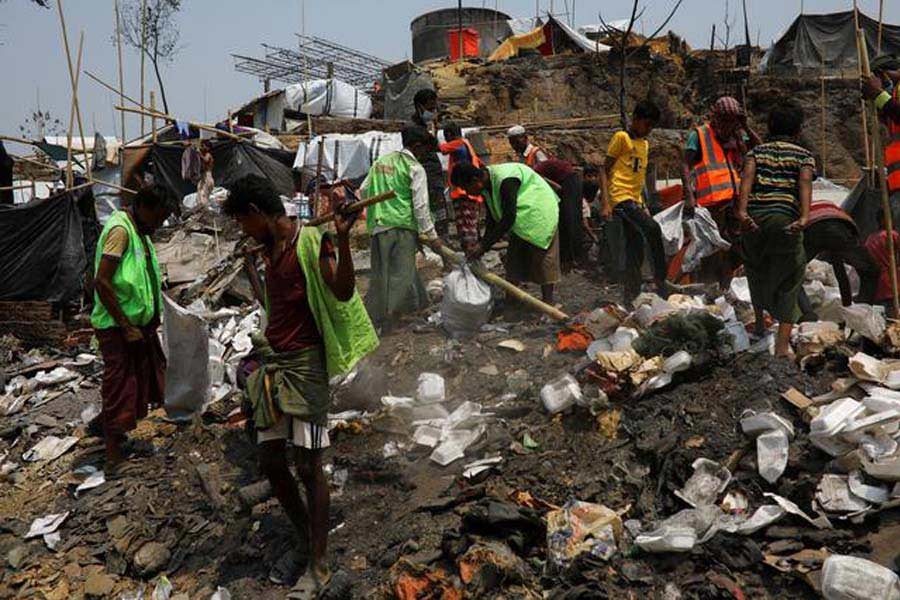 Rohingya volunteers cleaning up an area after a fire broke out earlier this week that destroyed thousands of shelters at the Balukhali refugee camp in Cox's Bazar recently -Reuters file photo