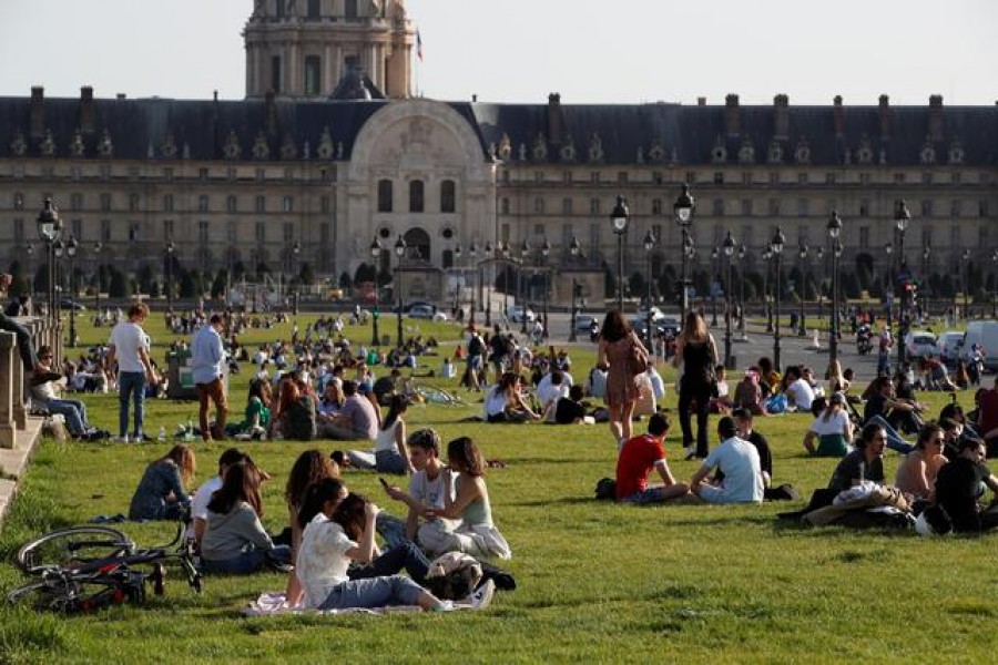 People enjoy a sunny and warm weather sitting on the grass near the Invalides in Paris amid the coronavirus disease (Covid-19) outbreak in France, March 31, 2021 — Reuters