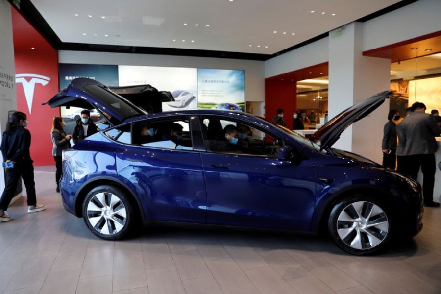 Visitors wearing face masks check a China-made Tesla Model Y sport utility vehicle (SUV) at the electric vehicle maker's showroom in Beijing, China on January 5, 2021 — Reuters/Files