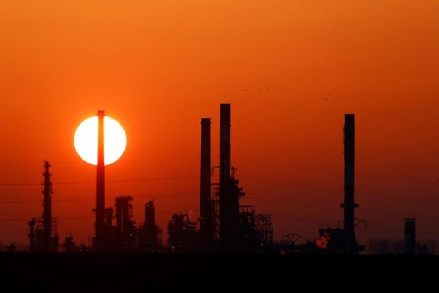 The sun sets behind the chimneys of the Total Grandpuits oil refinery, southeast of Paris, France, March 1, 2021 — Reuters/Files