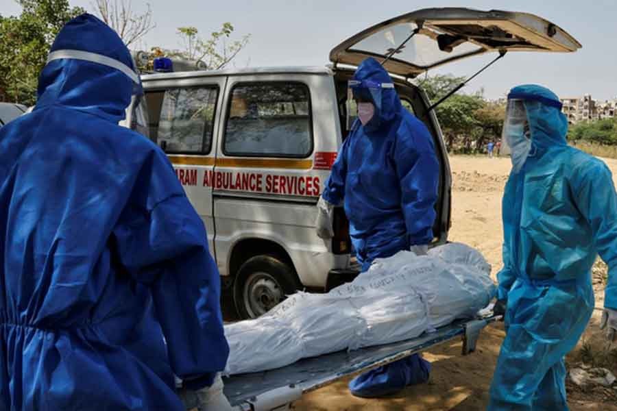 Health workers carry the body of a man who died from the coronavirus disease (COVID-19), for burial at a graveyard in New Delhi of India on Friday -Reuters photo