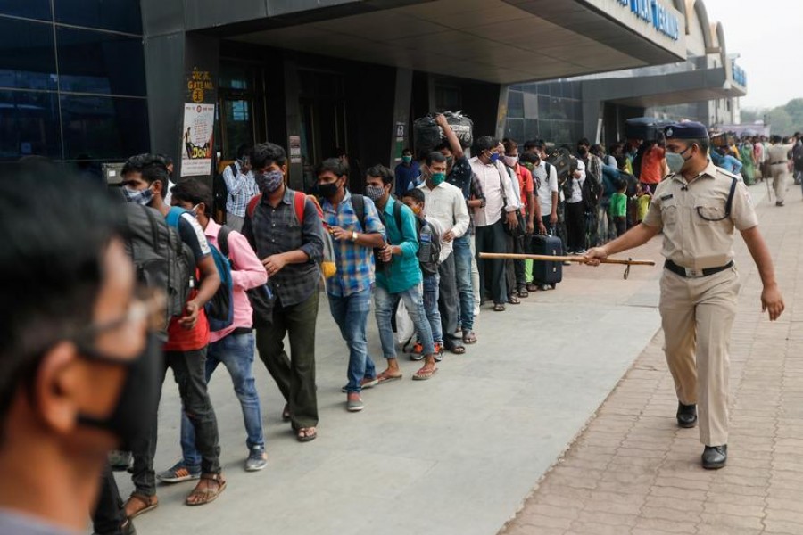 A police officer points at people in line at a railway station amidst the spread of the coronavirus disease (COVID-19) in Mumbai, India, April 11, 2021. REUTERS/Francis Mascarenhas