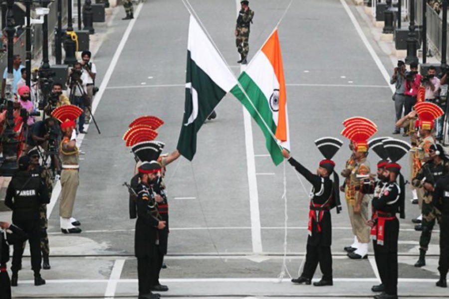 Pakistani Rangers (wearing black uniforms) and Indian Border Security Force (BSF) officers lower their national flags during parade on the Pakistan's 72nd Independence Day, at the Pakistan-India joint check-post at Wagah border, near Lahore, Pakistan on August 14, 2019 — Reuters/Files