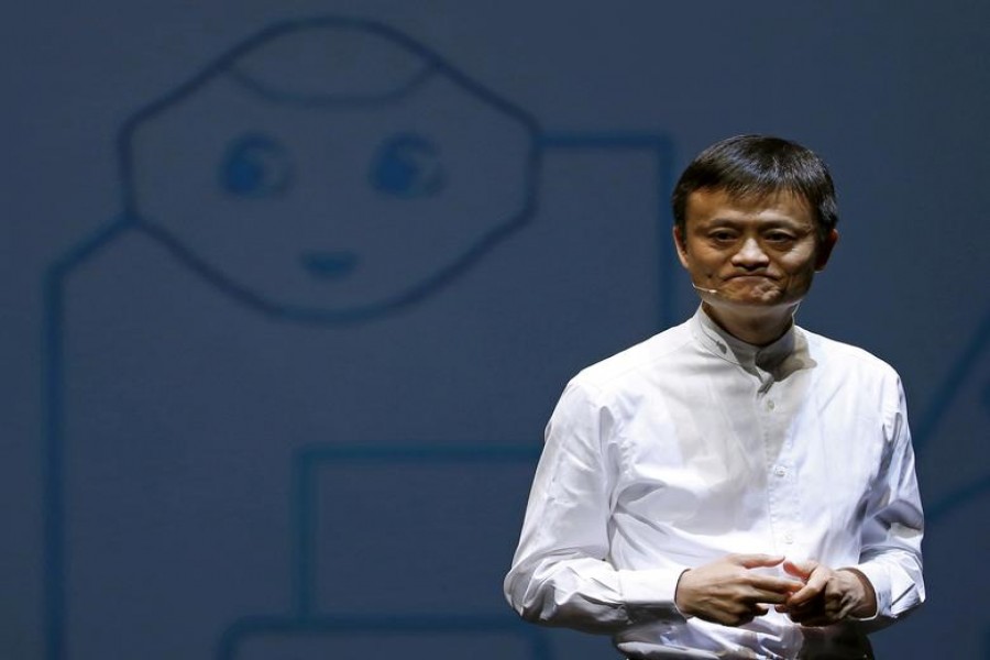 Jack Ma, founder and executive chairman of China's Alibaba Group, speaks in front of a picture of SoftBank's human-like robot named 'pepper' during a news conference in Chiba, Japan, June 18, 2015. REUTERS/Yuya Shino/File Photo/File Photo