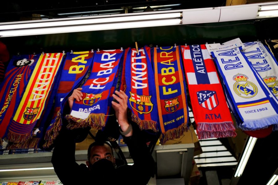 FC Barcelona, Atletico Madrid and Real Madrid scarves are displayed inside a store at Las Ramblas in Barcelona, Spain on April 19, 2021 — Reuters photro