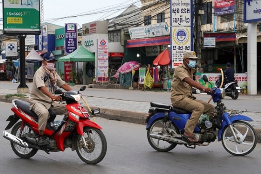 Cambodian policemen ride motorbikes as they hold sticks during lockdown to prevent the coronavirus disease (COVID-19) spread in Phnom Penh, Cambodia, Apr 21, 2021. REUTERS