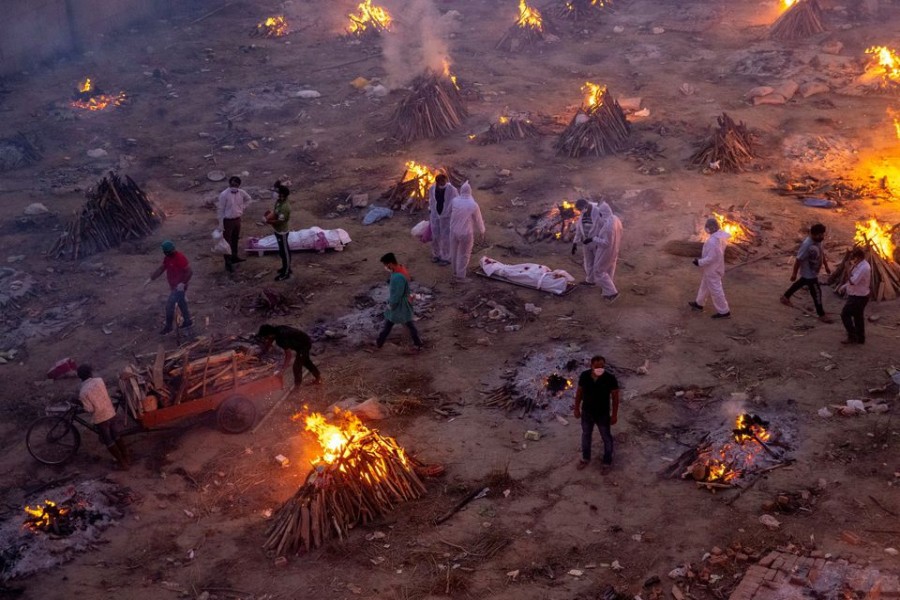 People wait to cremate victims who died due to the coronavirus disease (COVID-19), at a crematorium ground in New Delhi, India, April 23, 2021. REUTERS