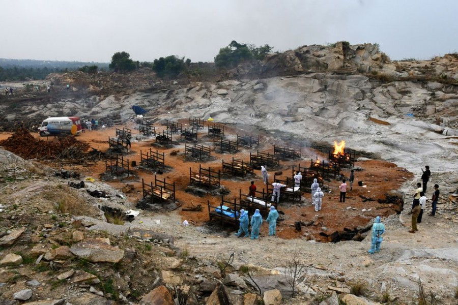 Volunteers and relatives prepare to cremate the bodies of persons who died due to the coronavirus disease (Covid-19), at a crematorium ground in Giddenahalli village on the outskirts of Bengaluru, India on May 2, 2021 — Reuters photo