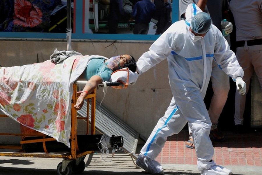 A health worker wearing personal protective equipment (PPE) carries a patient suffering from the coronavirus disease (Covid-19) outside the casualty ward at Guru Teg Bahadur hospital, in New Delhi, India, April 24, 2021 — Reuters/Files