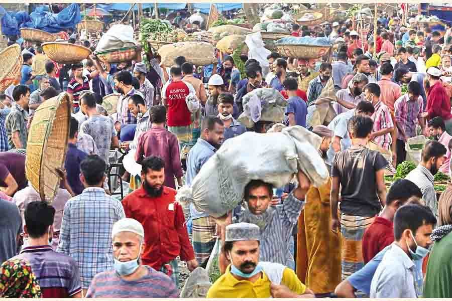 NO COVID-19 FEAR: Sellers and buyers going about their business at Karwan Bazar kitchen market in the city on Tuesday, paying no heed to mask mandate or social distancing norms — FE photo by KAZ Sumon