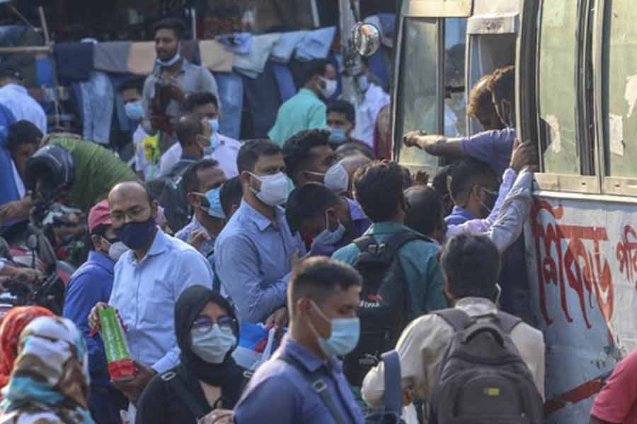 Passengers scramble to get on a bus in Dhaka on the first day of resumption of intra-city public transport services amid a coronavirus outbreak on Thursday -bdnews24.com photo