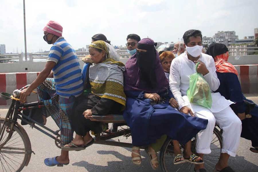 People are returning to the capital riding on a rickshaw van to join their workplaces after celebrating Eid-ul-Fitr. The picture was snapped from Babu Bazar Bridge on Monday —Focus Bangla Photo