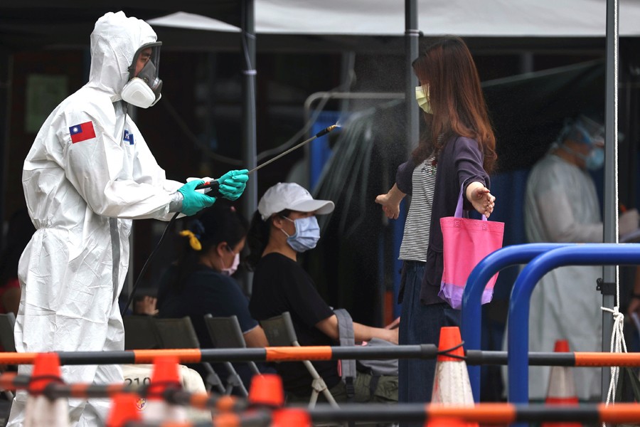 A soldier disinfects a person who is leaving a coronavirus disease (Covid-19) testing site following a surge of coronavirus infections in Taipei, Taiwan on May 19, 2021 — Reuters photo