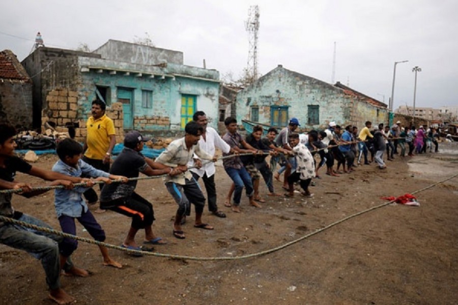 People pull a rope tied to a damaged boat after cyclone Tauktae hit, in Navabandar village, in the western state of Gujarat, India, May 18, 2021. Reuters