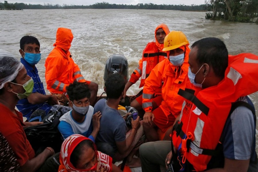 Members of the National Disaster Response Force (NDRF) evacuate people from a flooded area to safer places as Cyclone Yaas makes landfall at Ramnagar in Purba Medinipur district in the eastern state of West Bengal, India, May 26, 2021. REUTERS