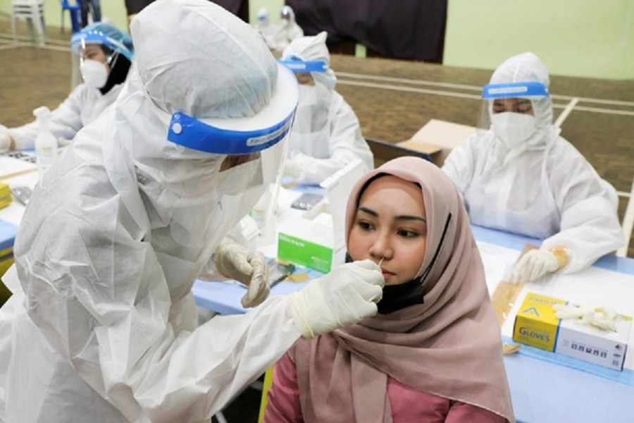 A medical worker collects a swab sample from a woman to be tested for the coronavirus disease (COVID-19) in Kuala Lumpur, Malaysia, May 11, 2021. REUTERS