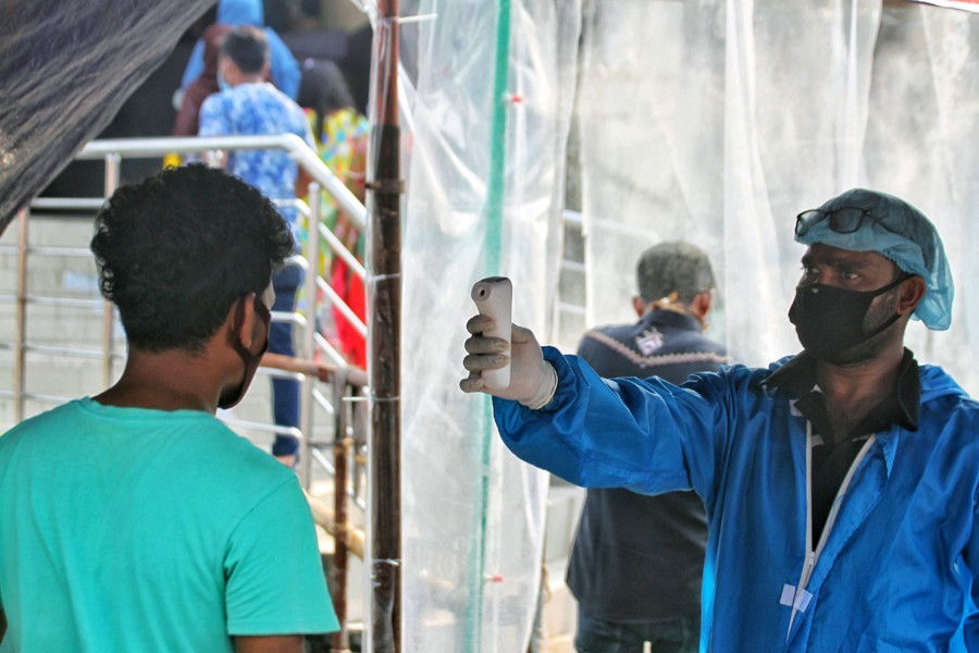 A man gets his temperature checked at one of the entrances of New Market in Dhaka as a precautionary measure against the spread of the coronavirus disease (COVID-19) — Collected