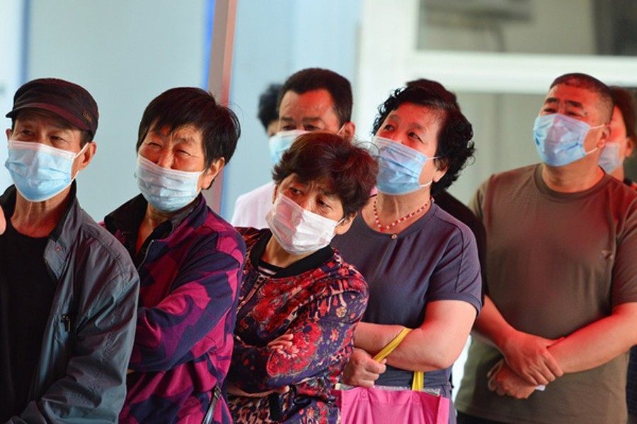 People wait in a line to get vaccinated with Sinopharm COVID-19 vaccine at the vaccination clinic of Gulou community health service center in Fuyang City. Reuters