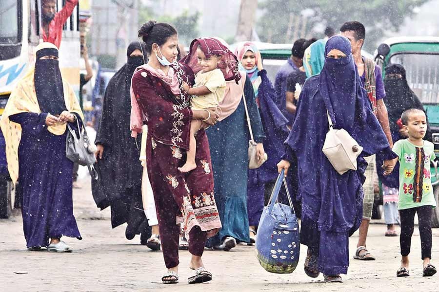 As road communication between Dhaka and other districts remains suspended due to Covid-19 restrictions, a group of women along with their children crossing the Signboard area in Narayanganj on foot to catch local buses to go to their destinations on Thursday — FE photo by KAZ Sumon