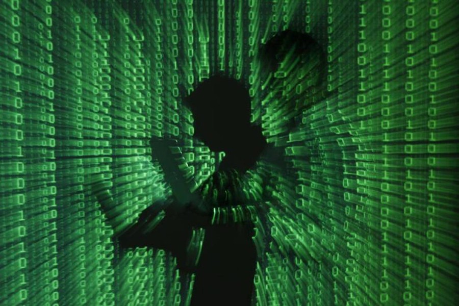 An illustration picture shows a projection of binary code on a man holding a laptop computer, in an office in Warsaw on June 24, 2013 — Reuters/Files