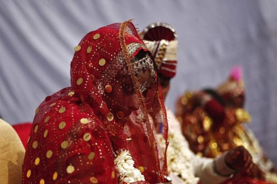 A bride and groom attend a mass wedding ceremony in New Delhi February 15, 2014. A total of 62 couples from across the Delhi state took their wedding vows on Saturday in the ceremony organised by Laadli Foundation Trust, a non-governmental organisation, organisers said. REUTERS