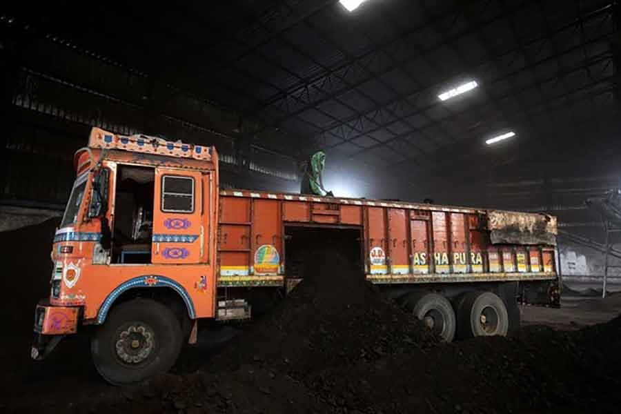 A worker shovelling coal in a supply truck at a yard on the outskirts of Ahmedabad in India in 2018 -Reuters file photo