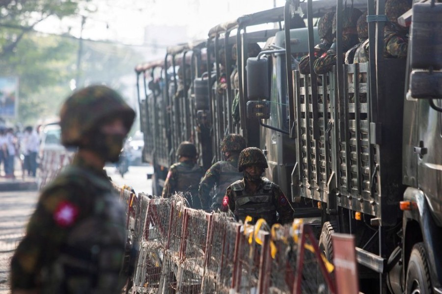 Soldiers stand next to military vehicles as people gather to protest against the military coup, in Yangon, Myanmar on February 15, 2021 — Reuters/Files