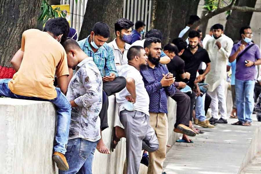 Despite the rising Covid cases, some people seem unconcerned about the health protocols as they roam outdoors on different pretexts. A number of such people while away the time gossiping at Motijheel Park in the city on Tuesday — FE photo by KAZ Sumon