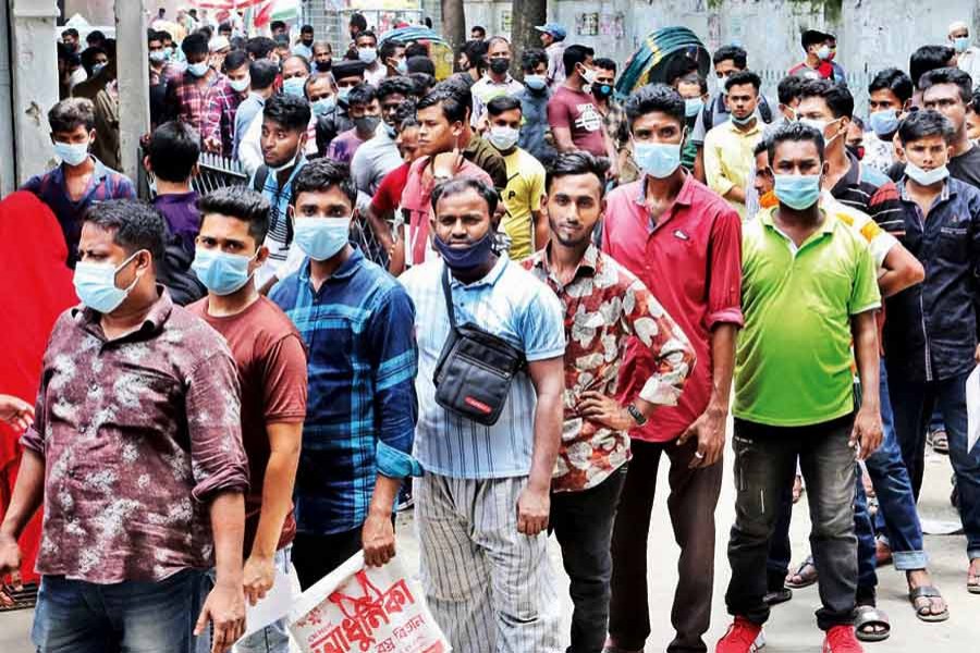 Without maintaining social distancing amid the Covid-19 surge, people waiting in a line to get vaccinated at the Dhaka Medical College Hospital on Saturday — FE photo