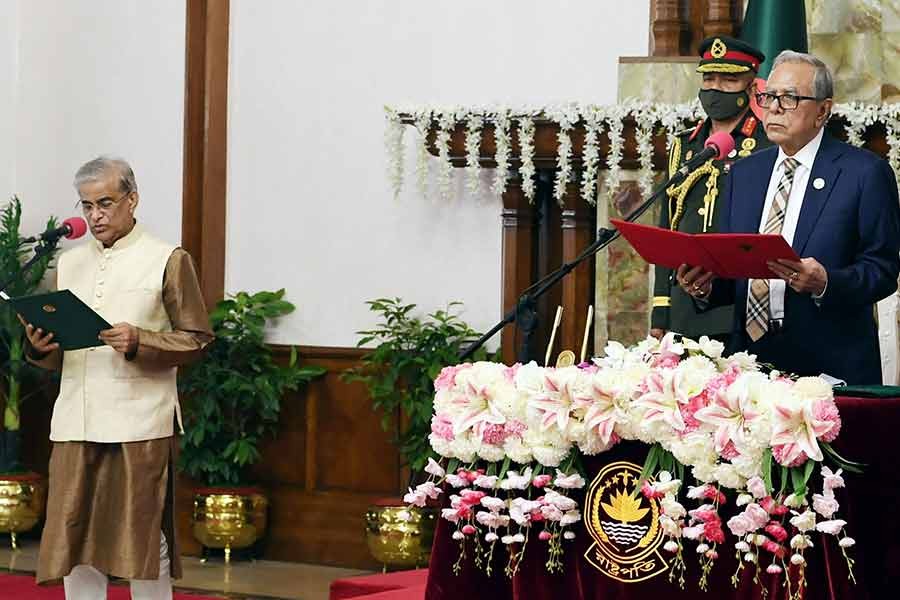 President Md Abdul Hamid administering the oath of office to Shamsul Alam as a state minister at the Bangabhaban on Sunday evening -PID Photo