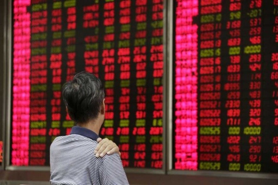 An investor looks at an electronic board showing stock information at a brokerage house in Beijing, August 27, 2015 — Reuters