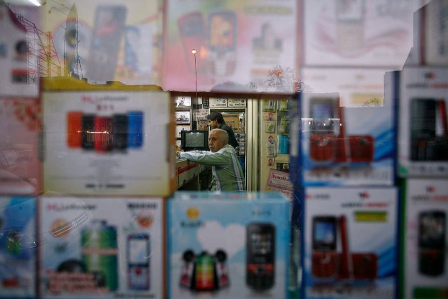 A vendor waits for customers inside his shop that sells mobile phones at Surat, in the western Indian state of Gujarat on January 4, 2013 — Reuters/Files