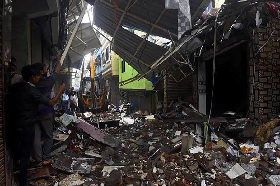 People using their mobile phones to take pictures of a collapsed building following rains in Mumbai of India on Friday -Reuters photo