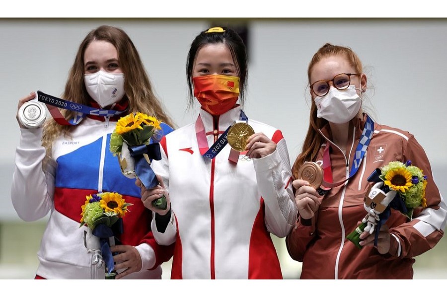 Tokyo 2020 Olympics - Shooting - Women's 10m Air Rifle - Medal Ceremony - Asaka Shooting Range, Tokyo, Japan – July 24, 2021. Gold medallist Yang Qian of China celebrates on the podium with silver medallist, Anastasiia Galashina of the Russian Olympic Committee and bronze medallist, Nina Christen of Switzerland – Reuters/Ann Wang