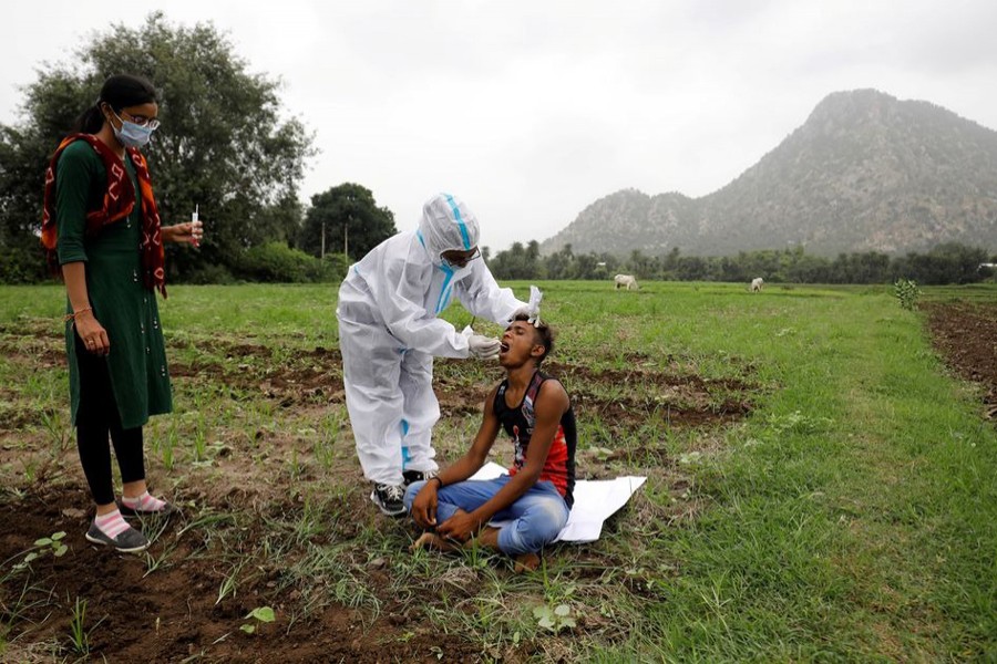 Healthcare worker Hemaben Raval collects a swab for a rapid antigen test from farmer Vinod Vajabhai Dabhi in his field, during a door-to-door vaccination drive amid the ongoing coronavirus disease (Covid-19) outbreak in Banaskantha district in the western state of Gujarat, India on July 23, 2021 — Reuters/Files