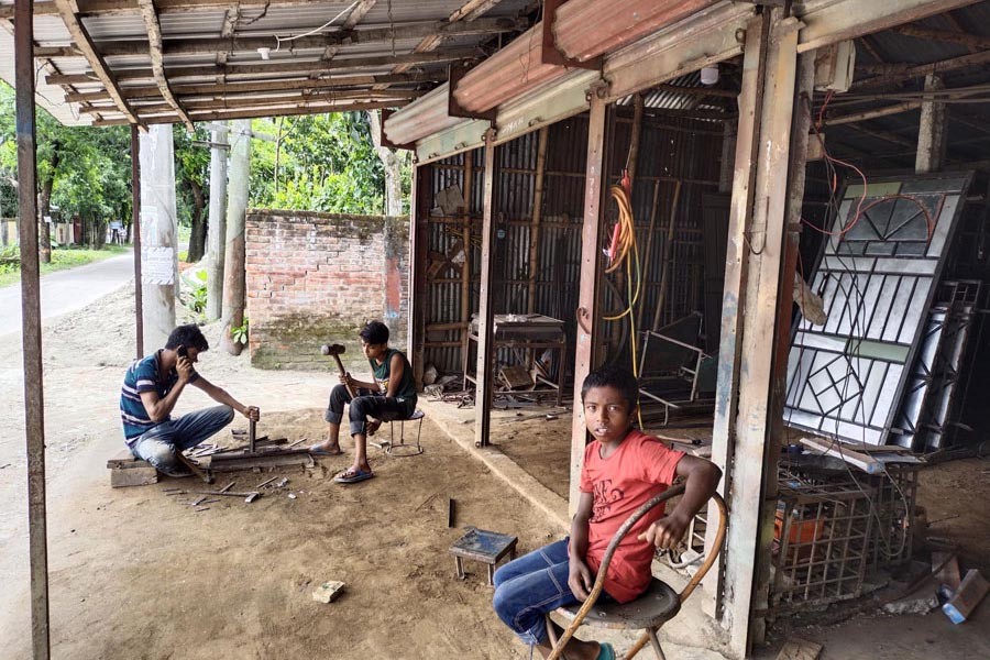 A sixth grader of a school working at a welding shop in Lalmonirhat — FE Photo