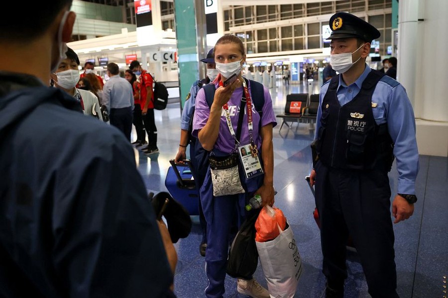 Belarusian sprinter Krystsina Tsimanouskaya is escorted by police officers at Haneda international airport in Tokyo, Japan on August 1, 2021 — Reuters photo