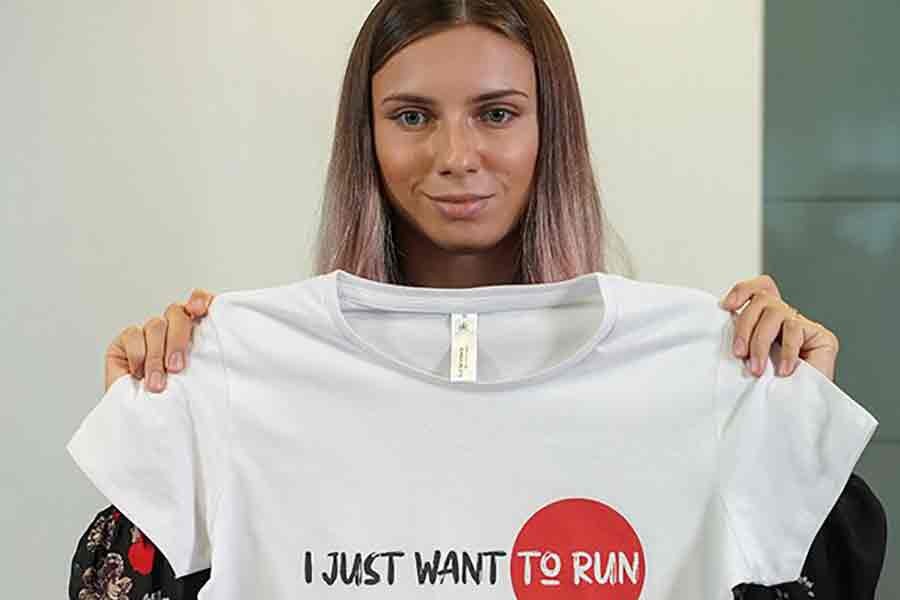 Belarusian sprinter Krystsina Tsimanouskaya, who left the Olympic Games in Tokyo and seeks asylum in Poland, holding a T-shirt at a news conference in Poland on Thursday -Reuters Photo