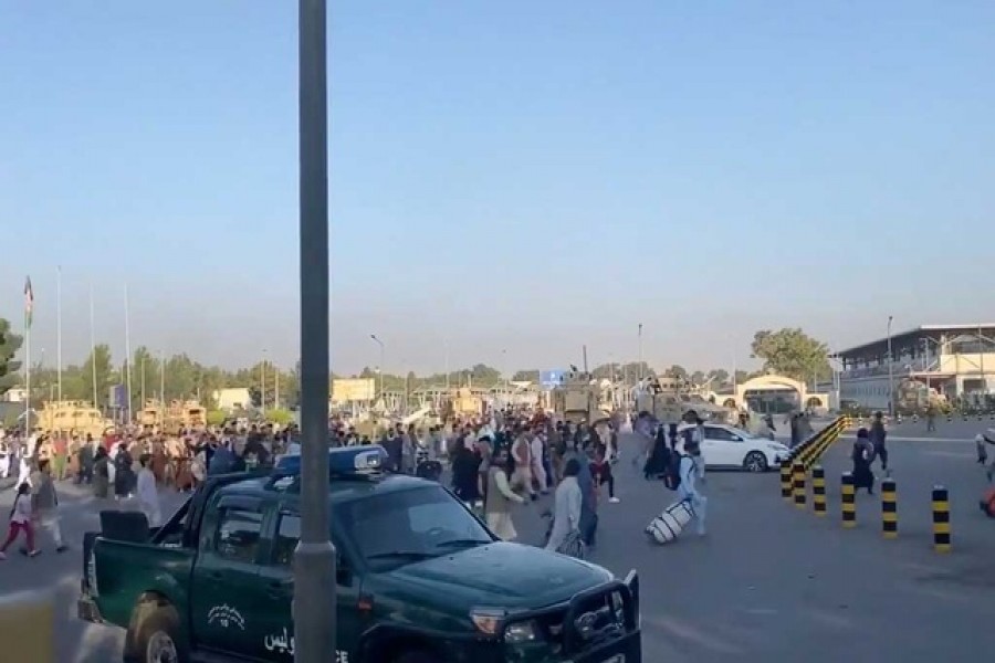 A horde of people run towards the Kabul Airport Terminal, after Taliban insurgents took control of the presidential palace in Kabul, August 16, 2021, in this still image taken from video obtained from social media — Jawad Sukhanyar/ Reuters