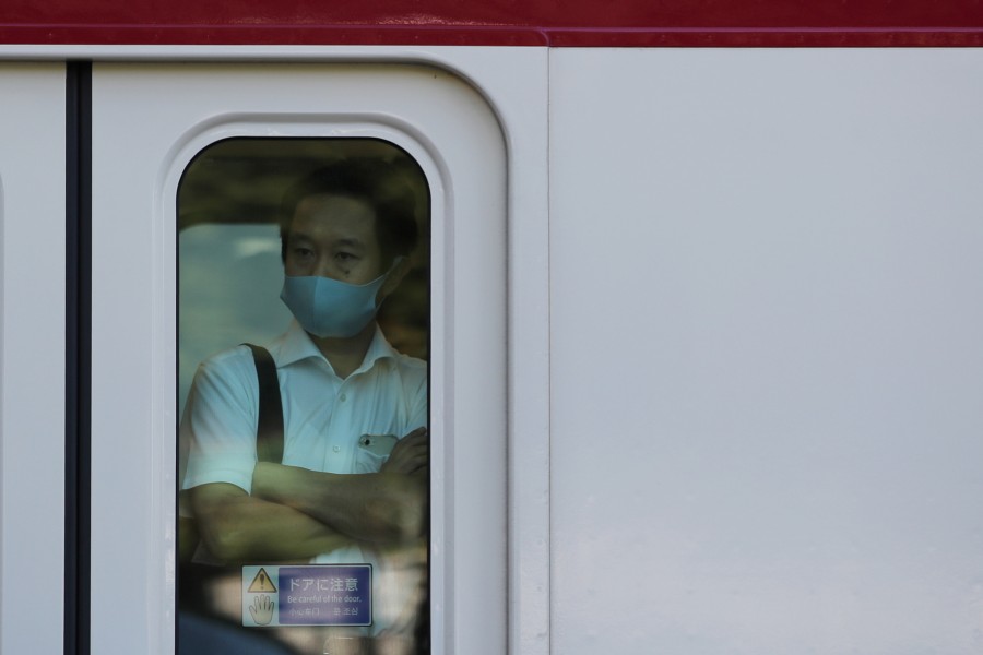 A man wearing a protective mask rides a train, amid the coronavirus disease (COVID-19) outbreak, in Tokyo, Japan, August 10, 2021. REUTERS/Kim Kyung-Hoon