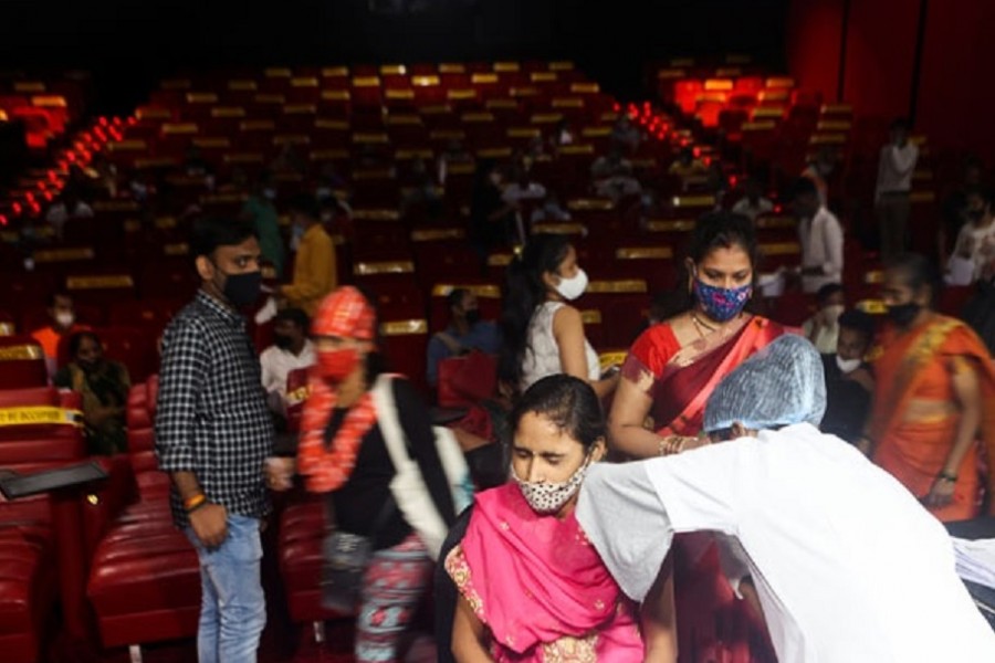 A woman reacts as she receives a dose of COVISHIELD, a vaccine against coronavirus disease (COVID-19) manufactured by Serum Institute of India, at a cinema hall in Mumbai, India, August 17, 2021. Reuters