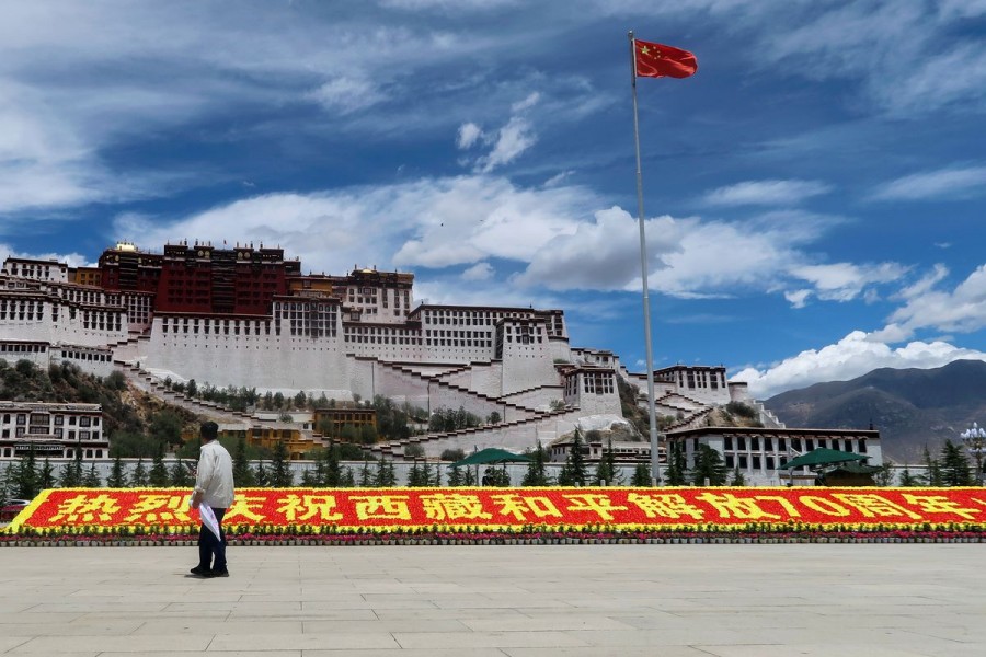 A man stands in front of a sign marking 70 years since Chinese rule over Tibet Autonomous Region, on the Potala Palace Square during a government-organised media tour to Lhasa, Tibet Autonomous Region, China June 1, 2021 - Reuters