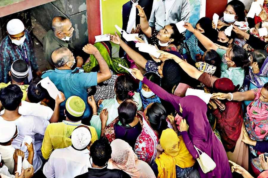 With photocopies of National ID cards in their hands, people scramble to enter a mass vaccination centre in Hatkhola area of the city recently, without caring about Covid-19 safety protocols —FE file photo