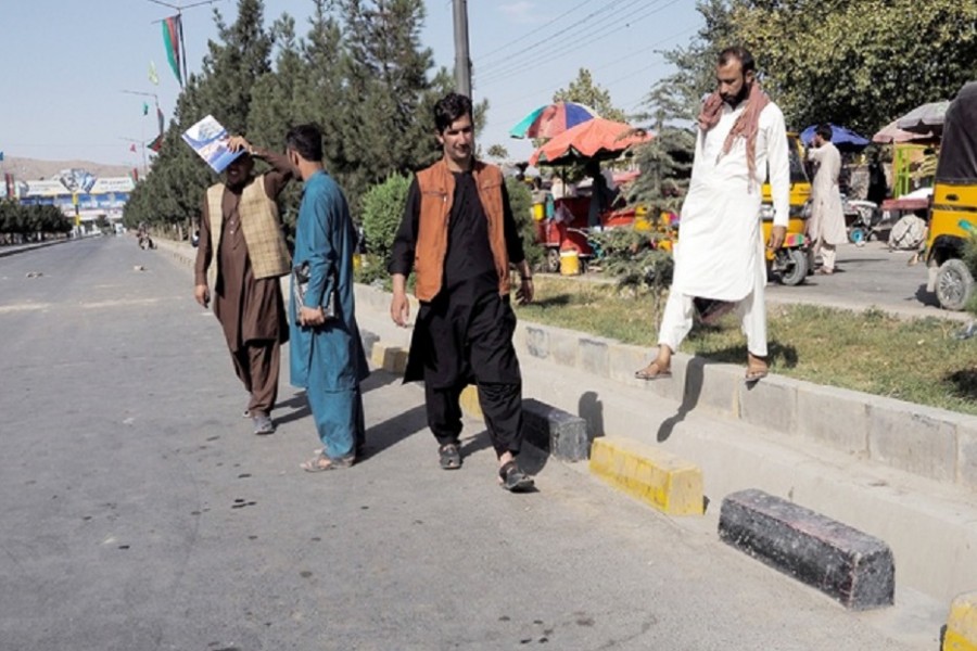 People walk on the street leading to the airport's Abbey gate where a blast occurred two days earlier, in Kabul, Afghanistan August 28, 2021. REUTER/Stringer