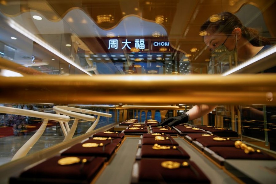 A salesperson poses with Heritage Gold jewellery at jeweller Chow Tai Fook’s retail store in Shanghai, China August 18, 2021. Picture taken August 18, 2021. REUTERS/Aly Song