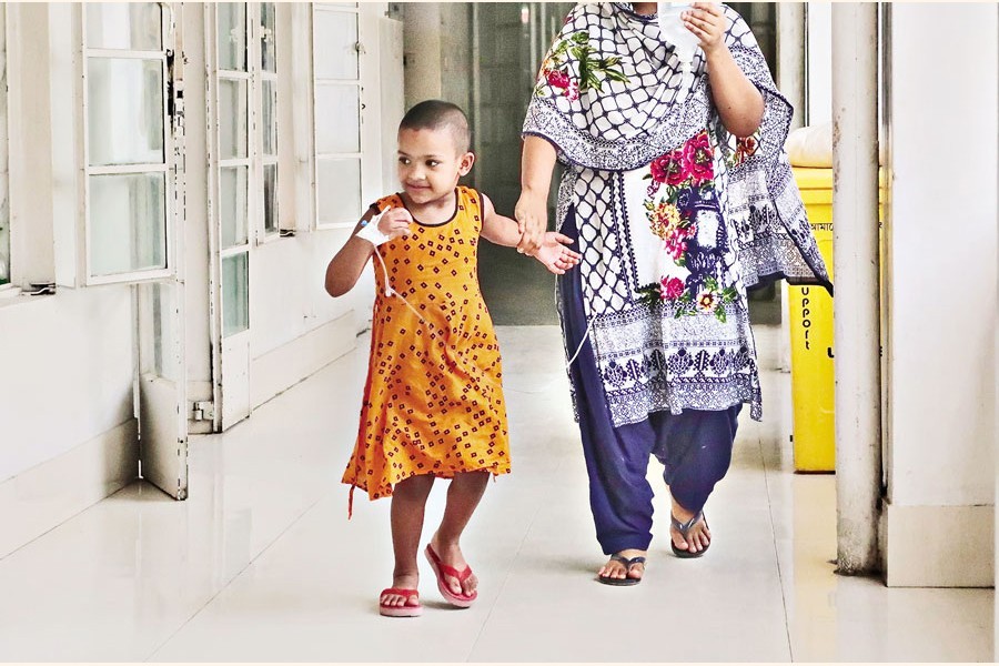 Ayesha, a little girl undergoing treatment for dengue fever at Holy Family Red Crescent Medical College Hospital in the city, is taking an evening stroll on the hospital corridor on Monday. Amid Covid crisis, dengue sets alarm bells ringing for residents, especially for children — FE photo by Shafiqul Alam