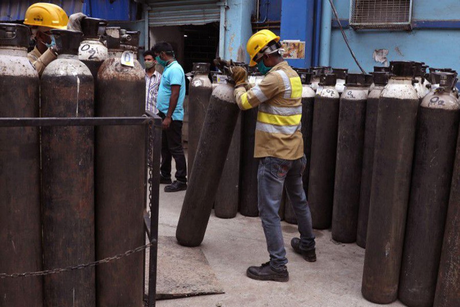 Workers load empty oxygen cylinders onto a supply truck for refilling, at the Medical College and Hospital, amid the spread of the coronavirus disease (Covid-19), in Kolkata, India on May 5, 2021 — Reuters/Files