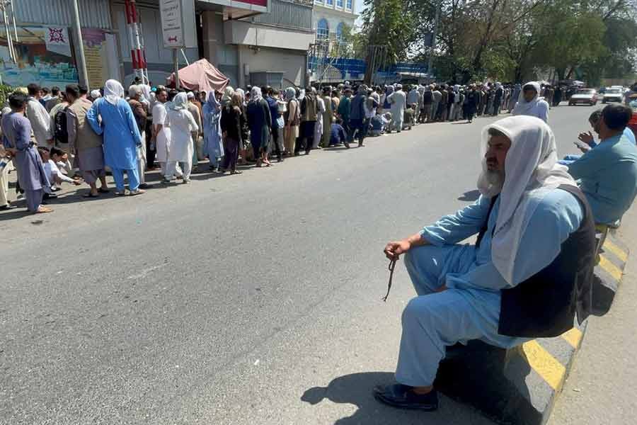 Afghans lining up outside a bank to take out their money after Taliban takeover in Kabul recently -Reuters file photo