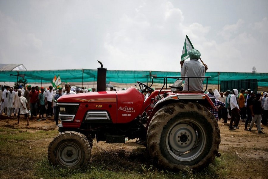 A farmer sits on a tractor as he attends a Maha Panchayat or grand village council meeting as part of a protest against farm laws in Muzaffarnagar in the northern state of Uttar Pradesh, India, September 5, 2021 — Reuters