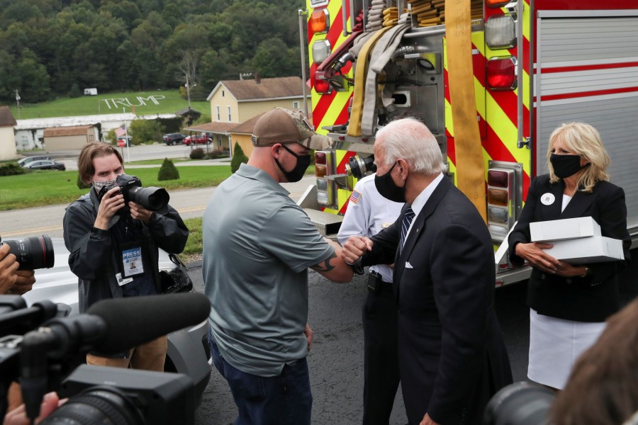 Democratic US presidential nominee and former Vice President Joe Biden elbow bumps a firefighter as he and his wife Jill deliver donuts and beer to firefighters at Shanksville fire station number 627 after visiting the nearby Flight 93 National Memorial to those killed when hijacked Flight 93 crashed into an open field on September 11, 2001, in Shanksville, Pennsylvania, September 11, 2020. REUTERS/Leah Millis